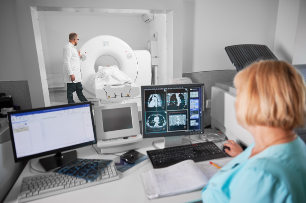 A radiographer at the CT control desk