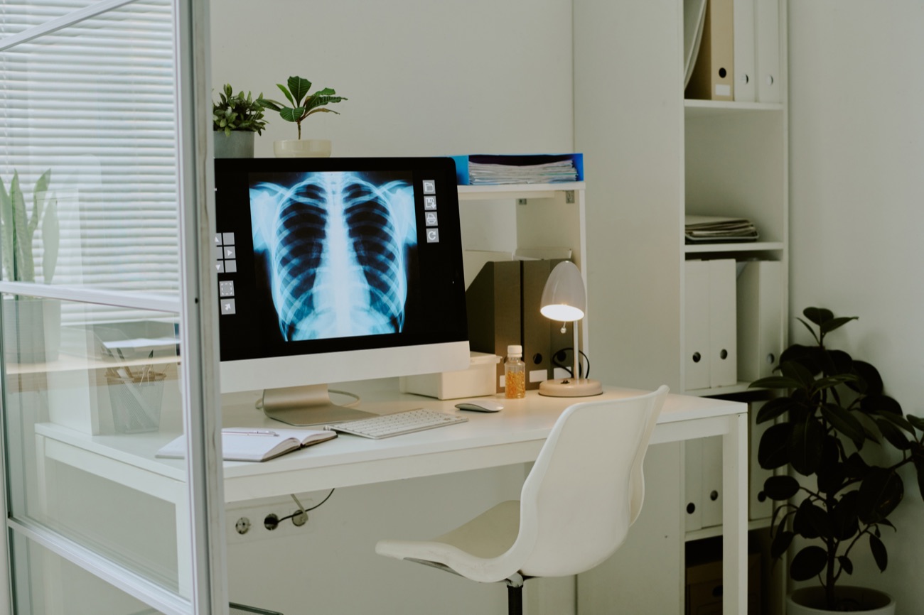 A reporting desk with a chest X-ray on screen